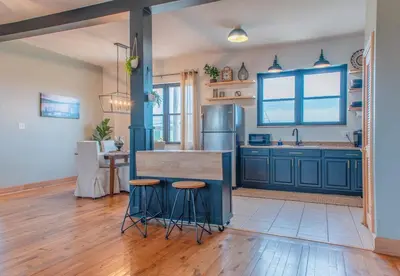 a kitchen with blue cabinets and a counter with stools at River City Loft in Portsmouth