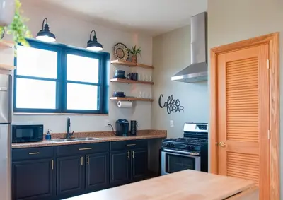 a kitchen with black cabinets and a sink and a window at River City Loft in Portsmouth