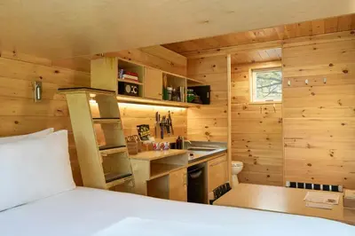 a room with a bed and a kitchen in a cabin at Postcard Cabins Beaver Creek, Outdoor Collection by Marriott Bonvoy in Lisbon