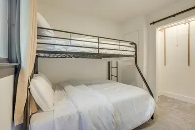 a bedroom with a bunk bed with white sheets at Spacious Riverfront Delaware Home with Views in Delaware