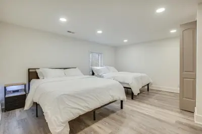 two beds in a room with white walls and wooden floors at Spacious Riverfront Delaware Home with Views in Delaware