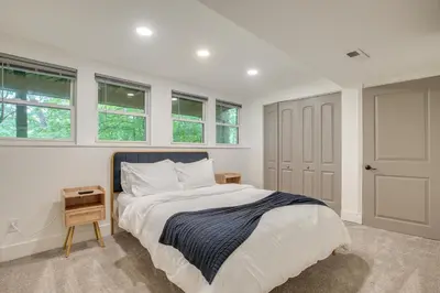a bedroom with a large bed and windows at Spacious Riverfront Delaware Home with Views in Delaware