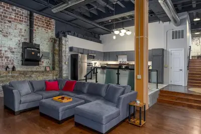 a living room with a couch and a kitchen at Unique and Charming Downtown Apt in Newark