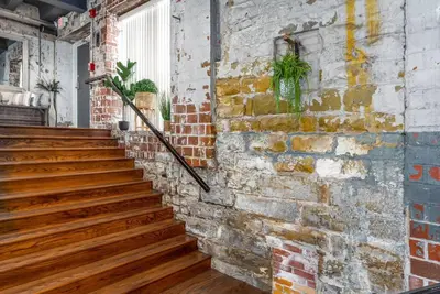 a brick wall with wooden stairs in a room at Unique and Charming Downtown Apt in Newark