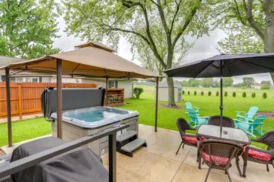 a backyard with a hot tub and an umbrella at Port Clinton Home Hot Tub, Steps to Portage River in Port Clinton