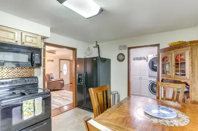 a kitchen and dining room with a table and a stove at Port Clinton Home Hot Tub, Steps to Portage River in Port Clinton