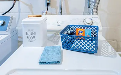 a bathroom with a blue basket on a white sink at Rachel's Private Hideaway with king bed, kitchen, laundry, parking and big yard in Toledo