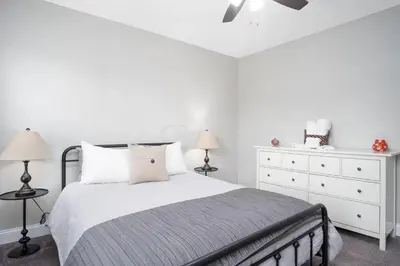 a white bedroom with a bed and a dresser at Beautiful 4 Bedroom House Near Downtown Columbus with Garage Parking and Backyard in Columbus