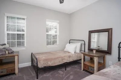 a bedroom with a bed and a mirror and two tables at Beautiful 4 Bedroom House Near Downtown Columbus with Garage Parking and Backyard in Columbus