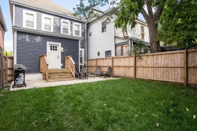 a backyard with a wooden fence and a house at Beautiful 4 Bedroom House Near Downtown Columbus with Garage Parking and Backyard in Columbus