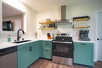 a kitchen with blue cabinets and a sink at Lake Erie BreezeYour Restful Vermilion 3BR Vacation Home close to Cedar Point in Vermilion