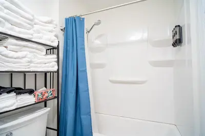 a bathroom with a shower and white towels at Lake Erie BreezeYour Restful Vermilion 3BR Vacation Home close to Cedar Point in Vermilion