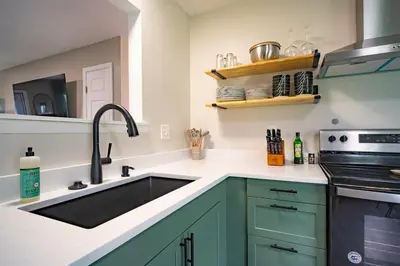 a kitchen with green cabinets and a sink at Lake Erie BreezeYour Restful Vermilion 3BR Vacation Home close to Cedar Point in Vermilion