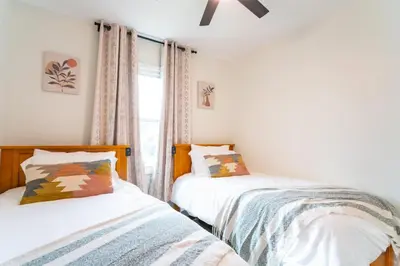 two beds in a room with a window at Lake Erie BreezeYour Restful Vermilion 3BR Vacation Home close to Cedar Point in Vermilion
