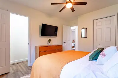a bedroom with a bed and a flat screen tv at Lake Erie BreezeYour Restful Vermilion 3BR Vacation Home close to Cedar Point in Vermilion
