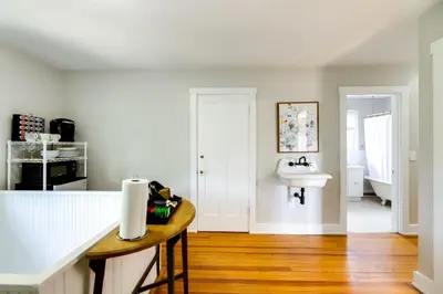 a white kitchen with a sink and a counter at Cincinnati Apartment 1 Mi to Hyde Park Square! in Cincinnati