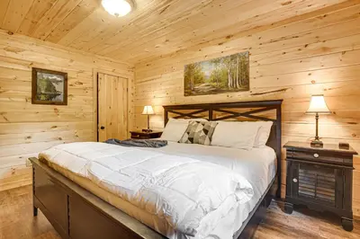 a bedroom with a bed in a log cabin at Hike, Fish and More! Cozy Cabin in Hocking Hills in South Bloomingville