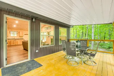 a screened in porch with a table and chairs at Hike, Fish and More! Cozy Cabin in Hocking Hills in South Bloomingville