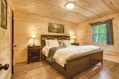 a bedroom with a bed in a log cabin at Hike, Fish and More! Cozy Cabin in Hocking Hills in South Bloomingville