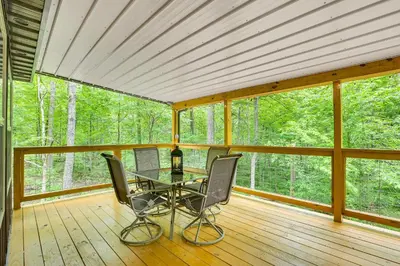 a screened in porch with a table and two chairs at Hike, Fish and More! Cozy Cabin in Hocking Hills in South Bloomingville