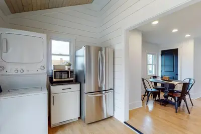 a kitchen with a refrigerator and a table with chairs at The Towpath Retreat-A Cozy Farmhouse Stay in Canal Fulton