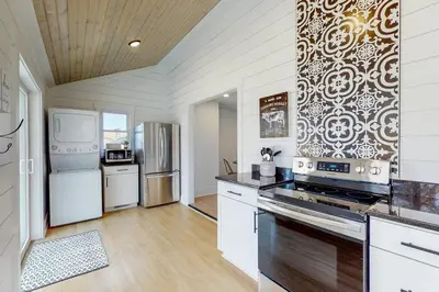 a kitchen with white cabinets and a stove top oven at The Towpath Retreat-A Cozy Farmhouse Stay in Canal Fulton