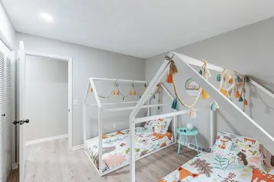 a white room with a bunk bed and a staircase at Game Day Getaway-Play Relax Make Memories in Canton