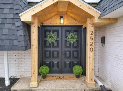 a black front door with a wooden pergola at Game Day Getaway-Play Relax Make Memories in Canton