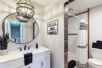 a white bathroom with a sink and a mirror at Game Day Getaway-Play Relax Make Memories in Canton
