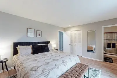 a white bedroom with a large bed and a table at Game Day Getaway-Play Relax Make Memories in Canton