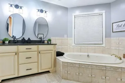 a bathroom with a tub and two mirrors at Hidden Acres Escape-A Bluegrass Retreat in Blaine