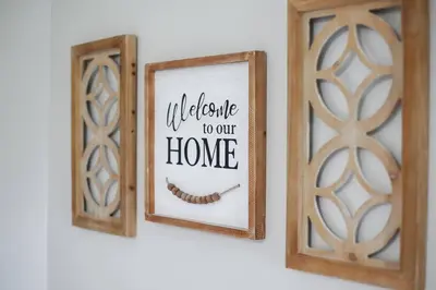 two wooden frames on a wall with a welcome to our home sign at Touchdown Bungalow-Charming HOF Village Home in Canton