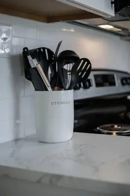 a white container filled with utensils on a kitchen counter at Touchdown Bungalow-Charming HOF Village Home in Canton