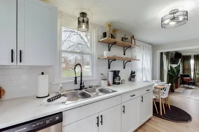 a white kitchen with a sink and a window at Touchdown Bungalow-Charming HOF Village Home in Canton