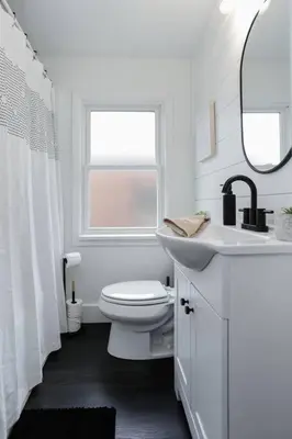 a white bathroom with a toilet and a sink at Touchdown Bungalow-Charming HOF Village Home in Canton