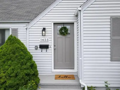 a white house with a door with a wreath on it at Football Hall of Fame Hideaway-Cozy and Convenient in Canton