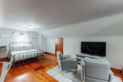 a living room with a tv and a couch and chairs at Football Hall of Fame Hideaway-Cozy and Convenient in Canton