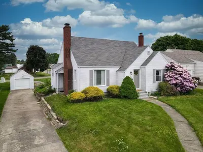 a white house with a brick chimney and a yard at Football Hall of Fame Hideaway-Cozy and Convenient in Canton