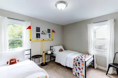 a bedroom with two beds and two windows at Football Hall of Fame Hideaway-Cozy and Convenient in Canton