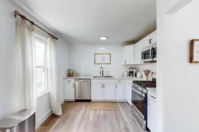 a kitchen with white cabinets and a stove top oven at The Huddle House-HOF Home Made for Families in Canton