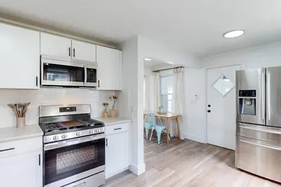 a kitchen with white cabinets and a stove top oven at The Huddle House-HOF Home Made for Families in Canton