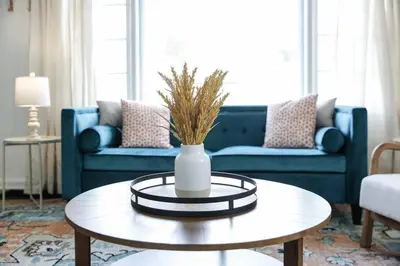 a living room with a blue couch and a vase on a table at The Huddle House-HOF Home Made for Families in Canton