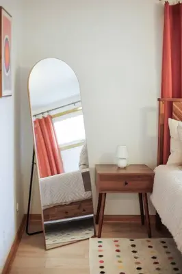 a mirror in a bedroom with a bed and a table at Gridiron Getaway-Where Families and Fans Unite in Canton