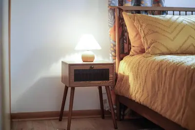 a nightstand with a lamp on it next to a bed at Gridiron Getaway-Where Families and Fans Unite in Canton