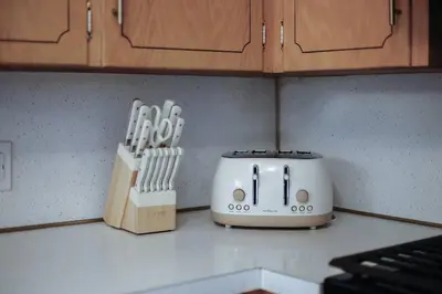 a toaster on a kitchen counter next to a knife block at Gridiron Getaway-Where Families and Fans Unite in Canton
