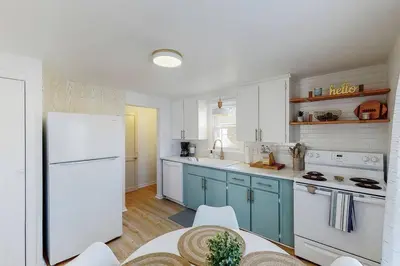 a kitchen with blue cabinets and a white refrigerator at End Zone Escape-Light and Bright HOF Village Home in Canton
