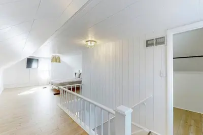 a white room with a staircase and white walls at End Zone Escape-Light and Bright HOF Village Home in Canton