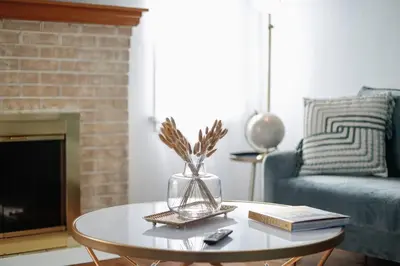 a living room with a table with a vase and books at End Zone Escape-Light and Bright HOF Village Home in Canton