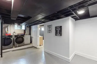 a laundry room with washing machines and a sign on a wall at Home Champions-HOF Village Comfort in Canton