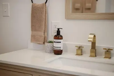 a bottle of wine sitting on a bathroom sink at The Perfect Pass-HOF Village Escape in Canton
